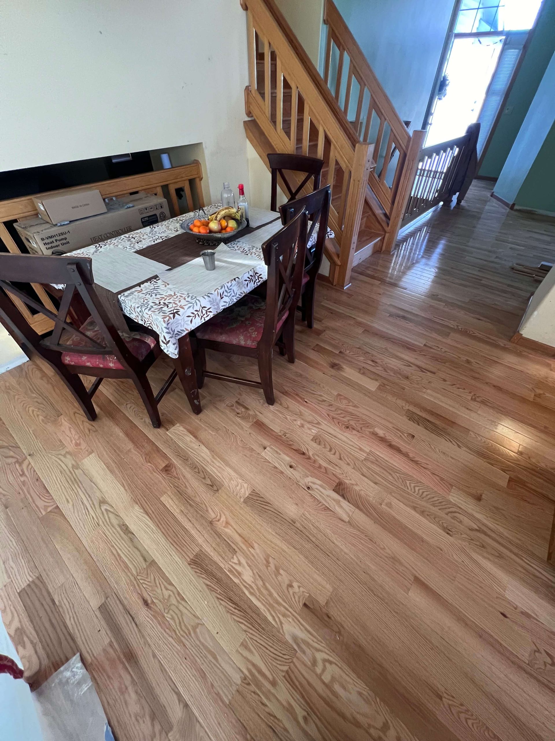 Oak hardwood floor installed in a dining room next to a staircase