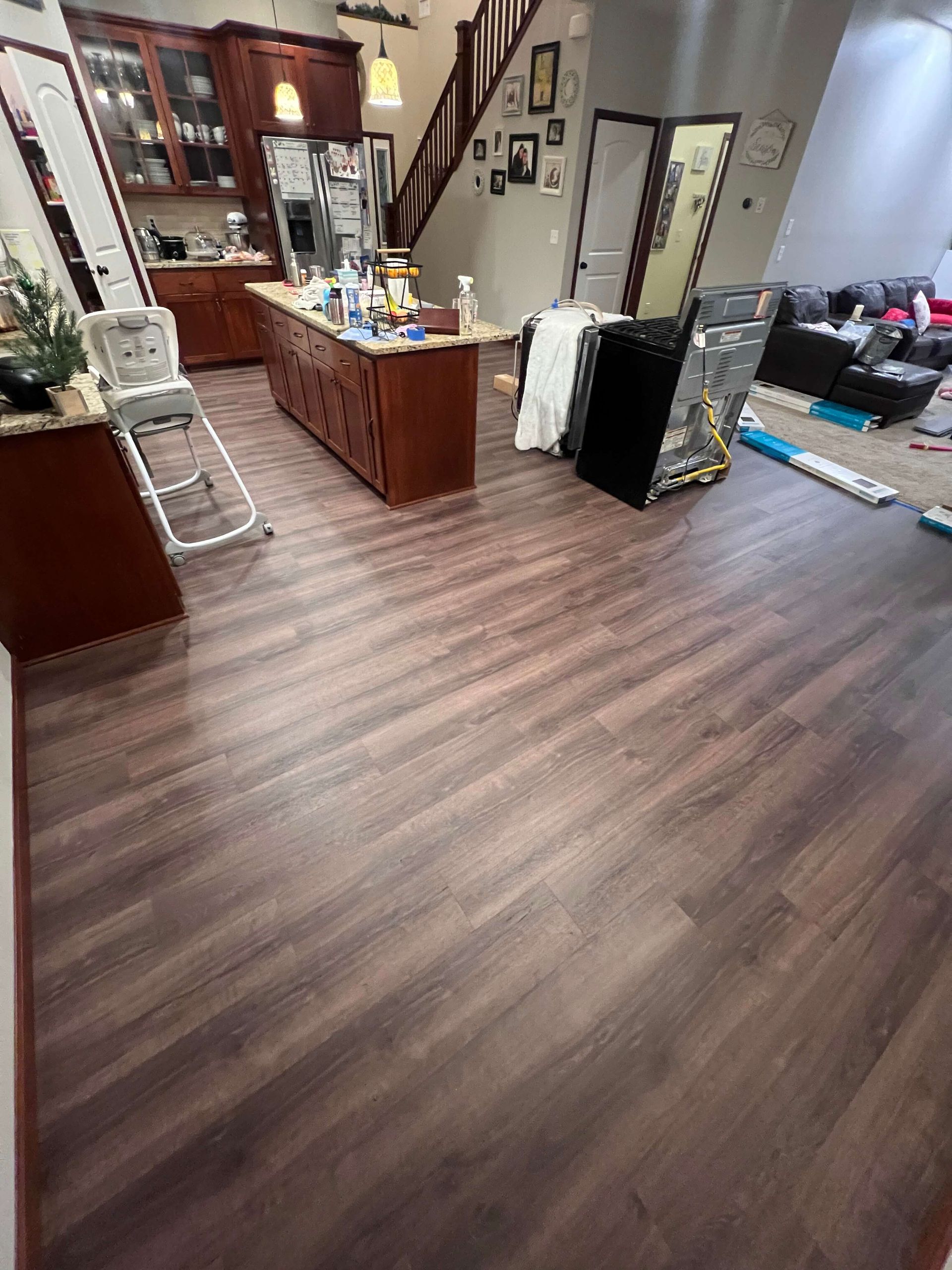 Wide luxury vinyl plank floor installed through a kitchen and living area